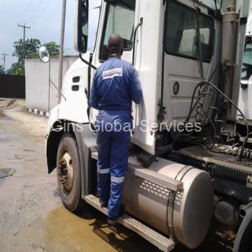 GGSL driver in branded coveralls mounting a Mack tractor unit