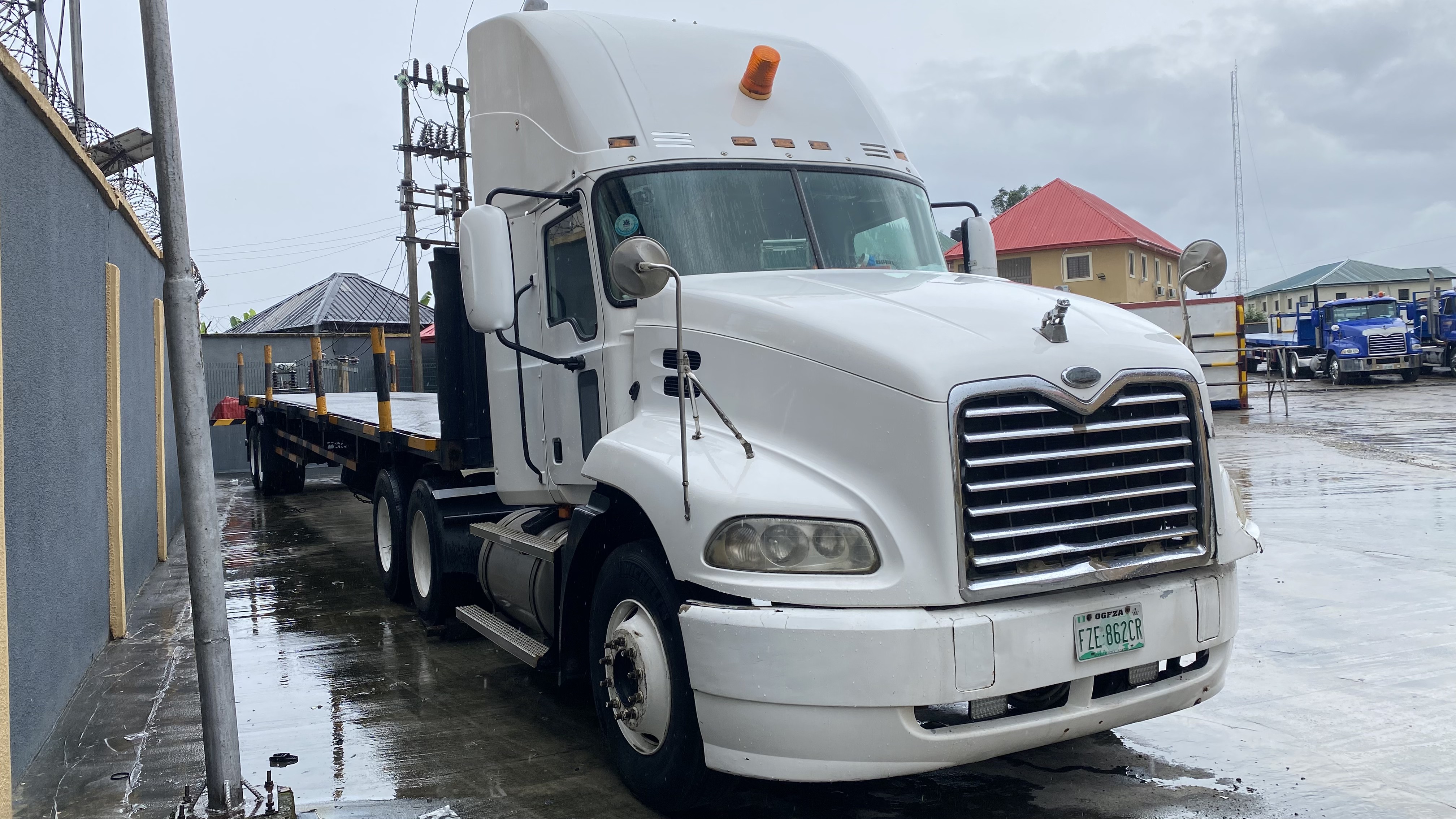 White Mack tractor unit coupled to a flatbed trailer