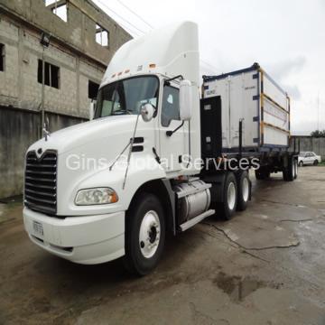 White Mack tractor unit coupled to a 40-foot container flatbed